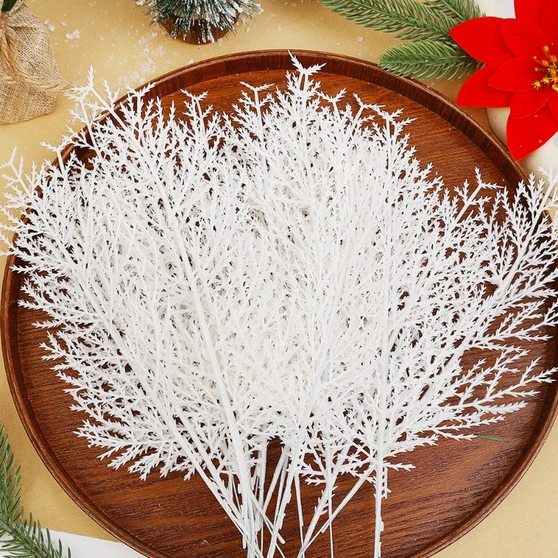 White decorative branches on a wooden plate with Christmas decorations in the background