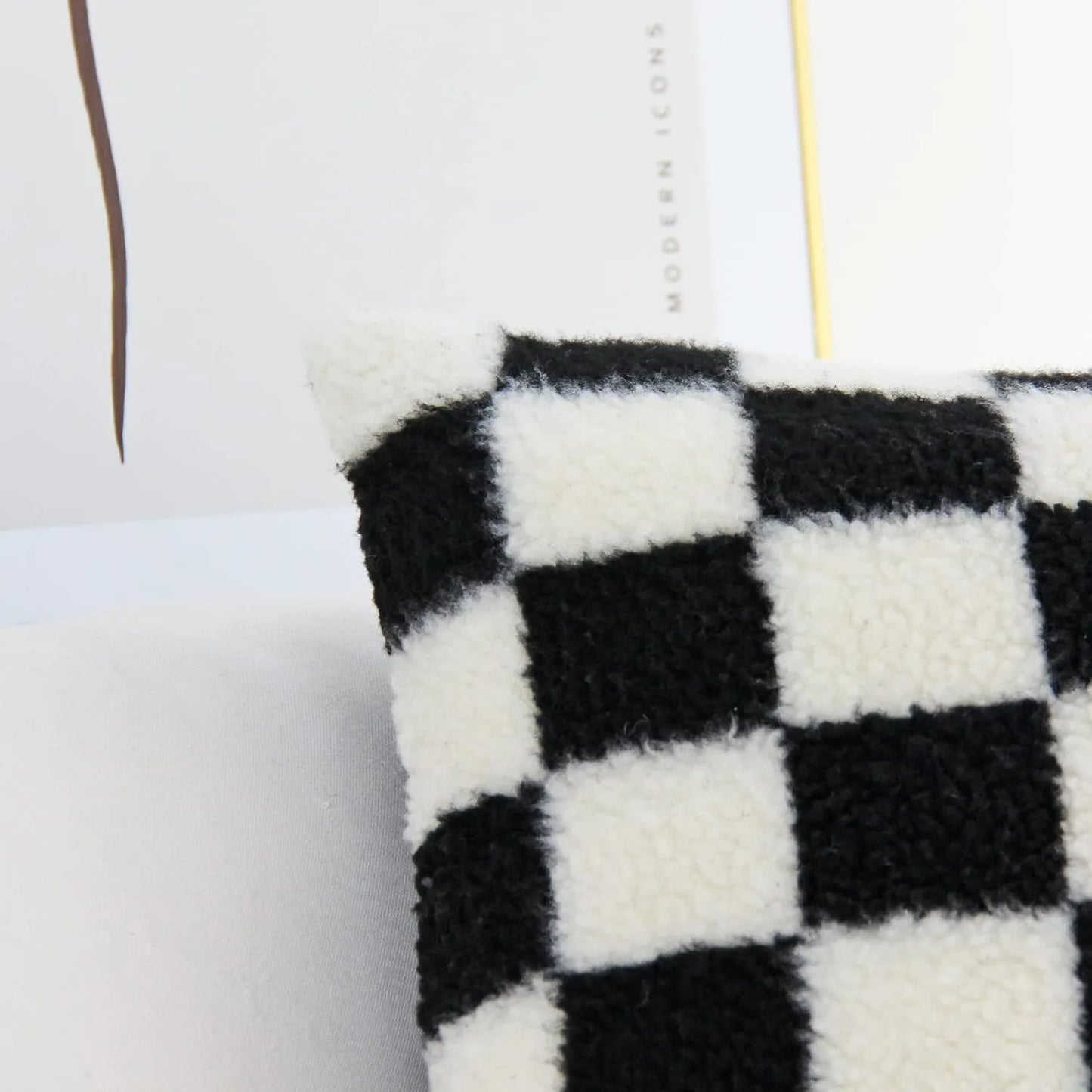 Black and white checkered pillow on a light gray sofa