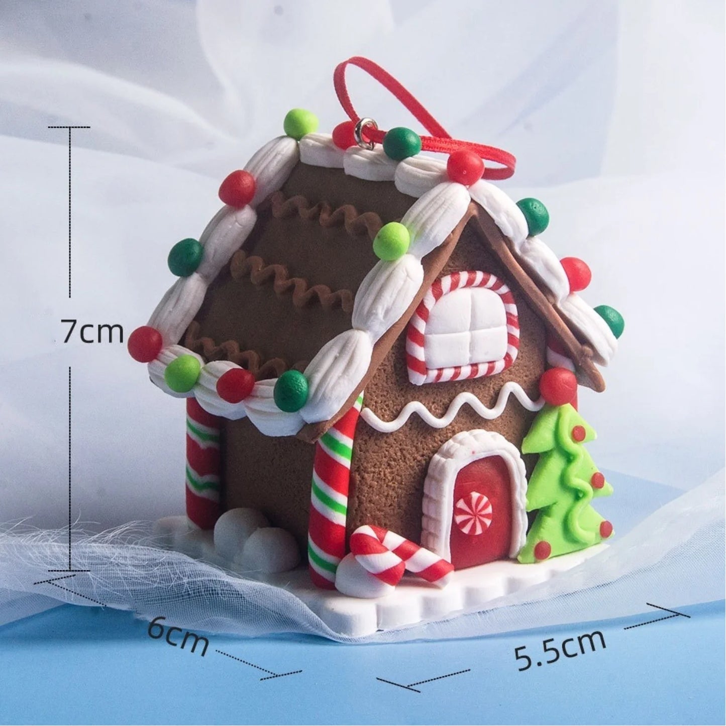 Decorative gingerbread house ornament with measurements on a white background
