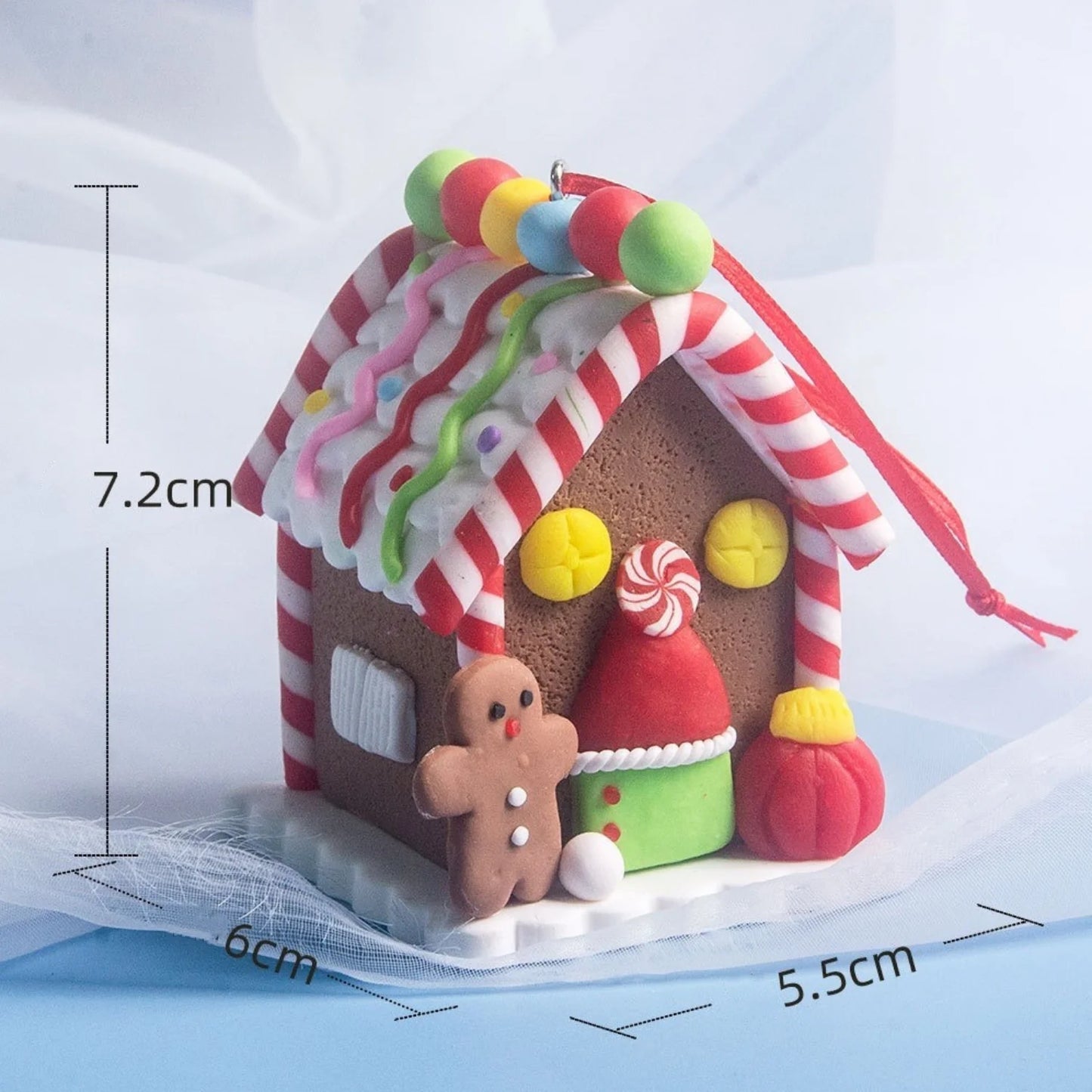 Decorative gingerbread house with candy roof and measurements on a white background
