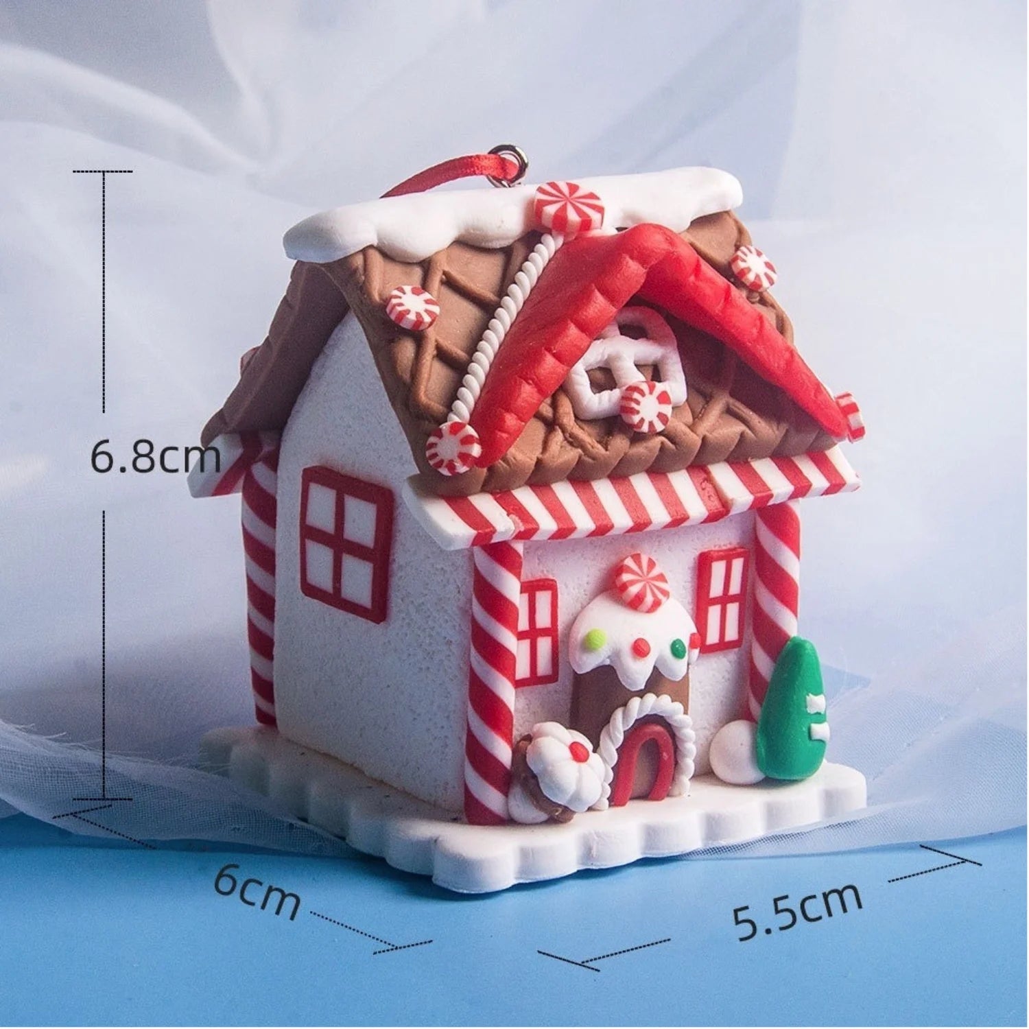Gingerbread house ornament with measurements on a light blue background