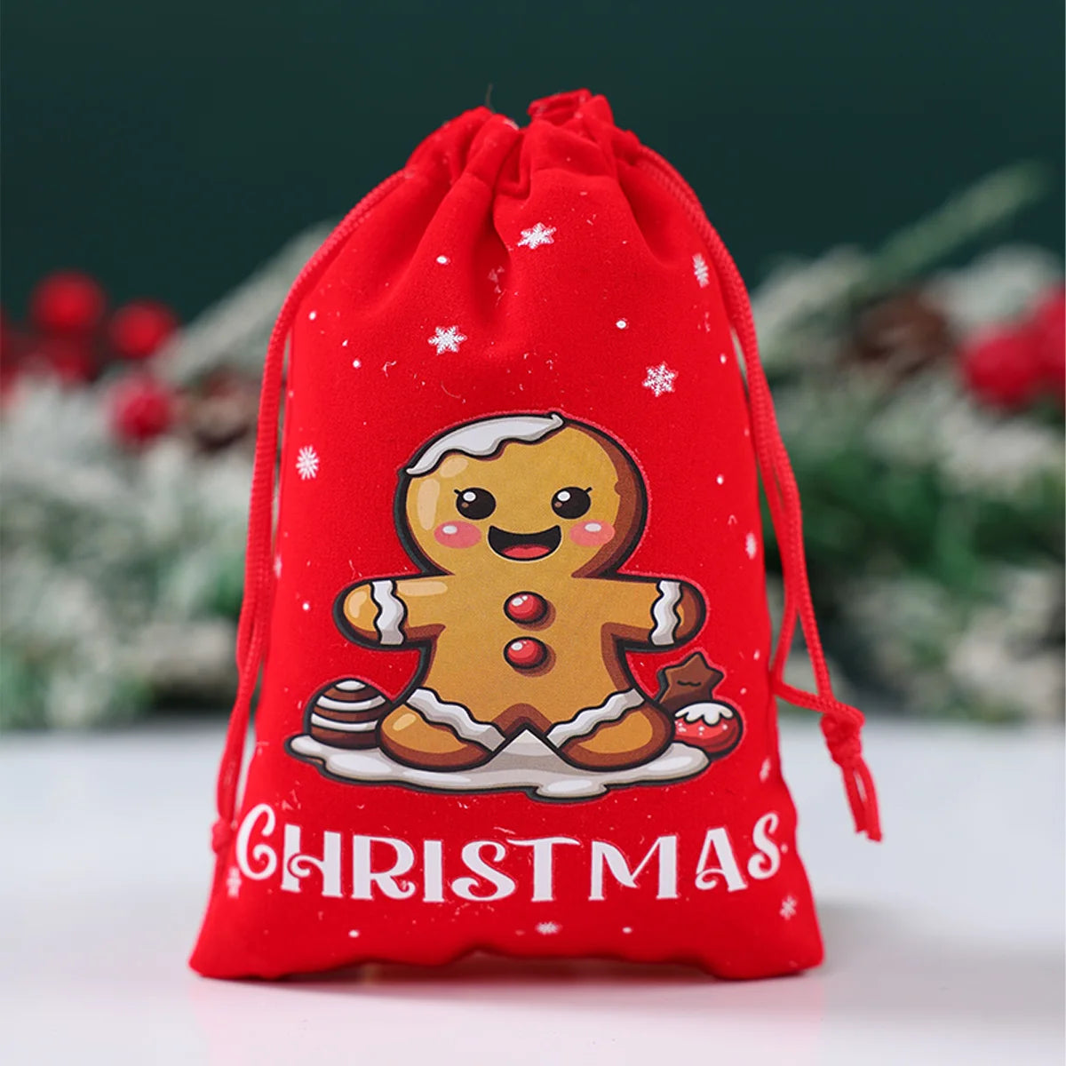 Red Christmas drawstring bag with a gingerbread man design on a blurred festive background.