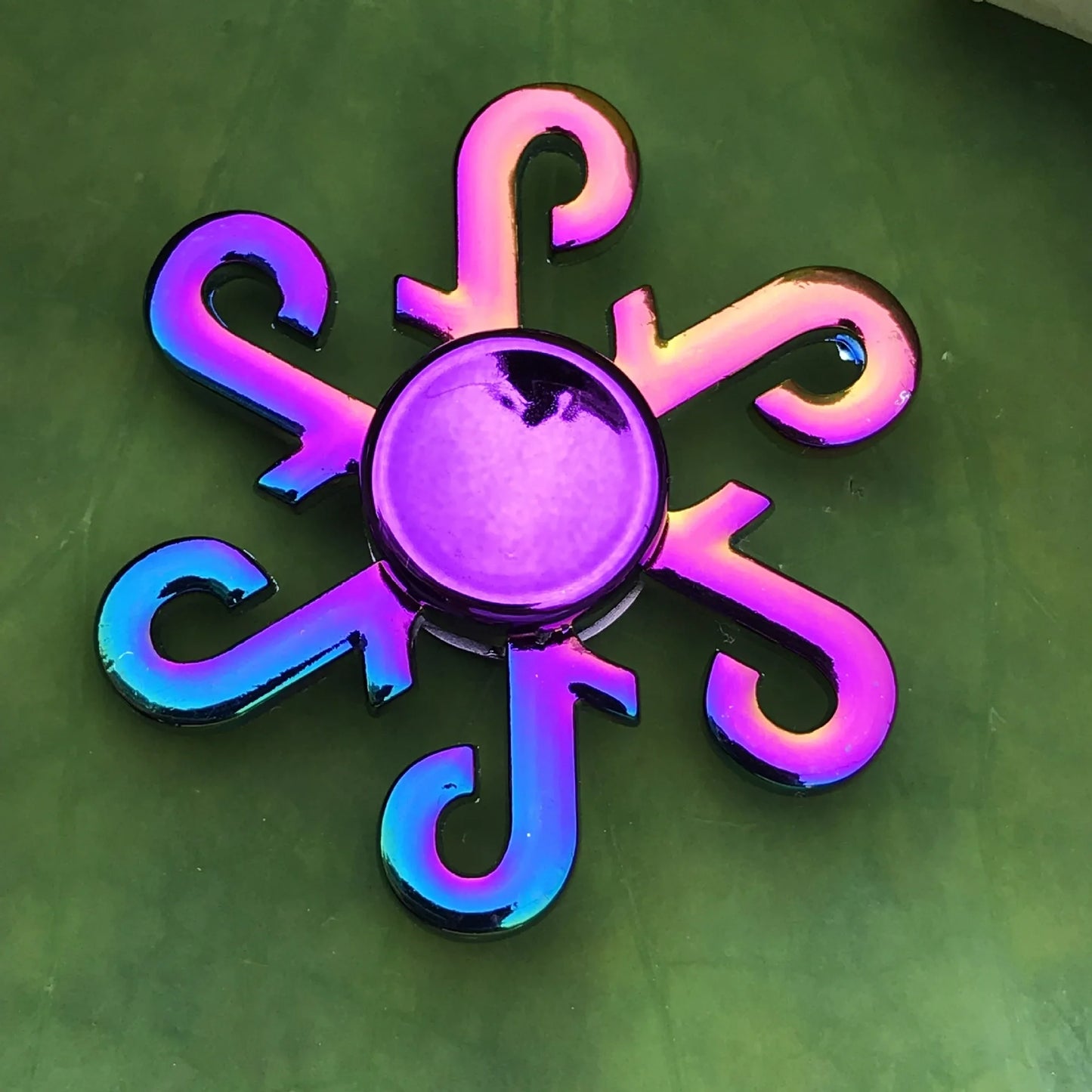 Colorful fidget spinner on a green background hook shape
