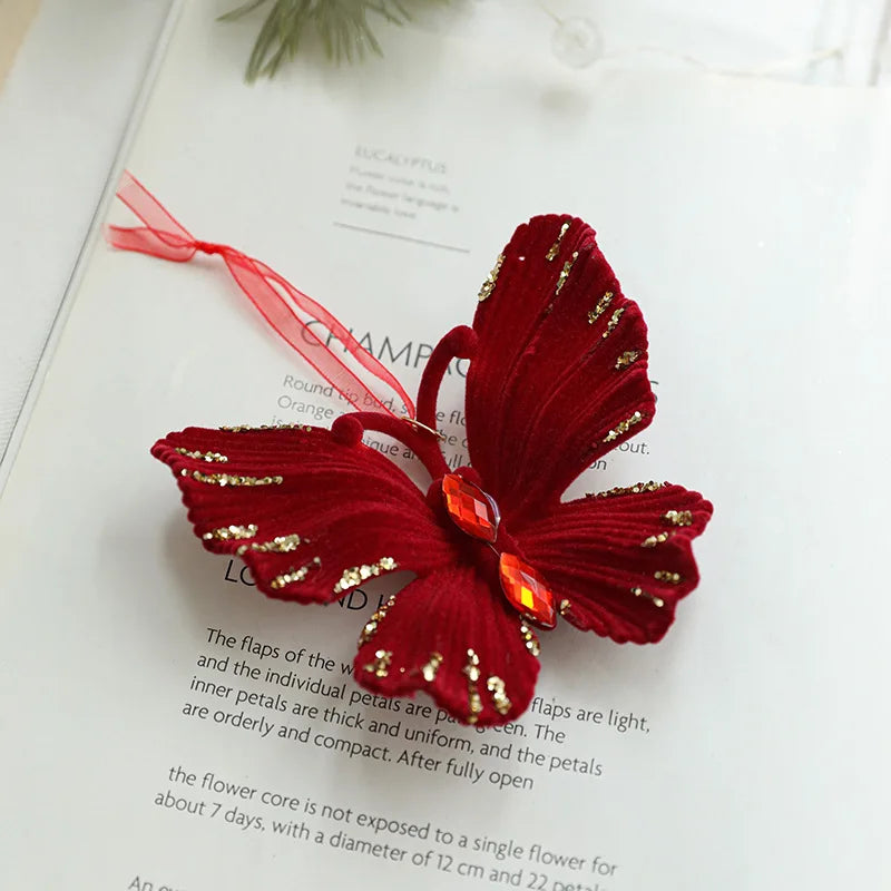 Red butterfly-shaped hair clip with gold accents on a book page