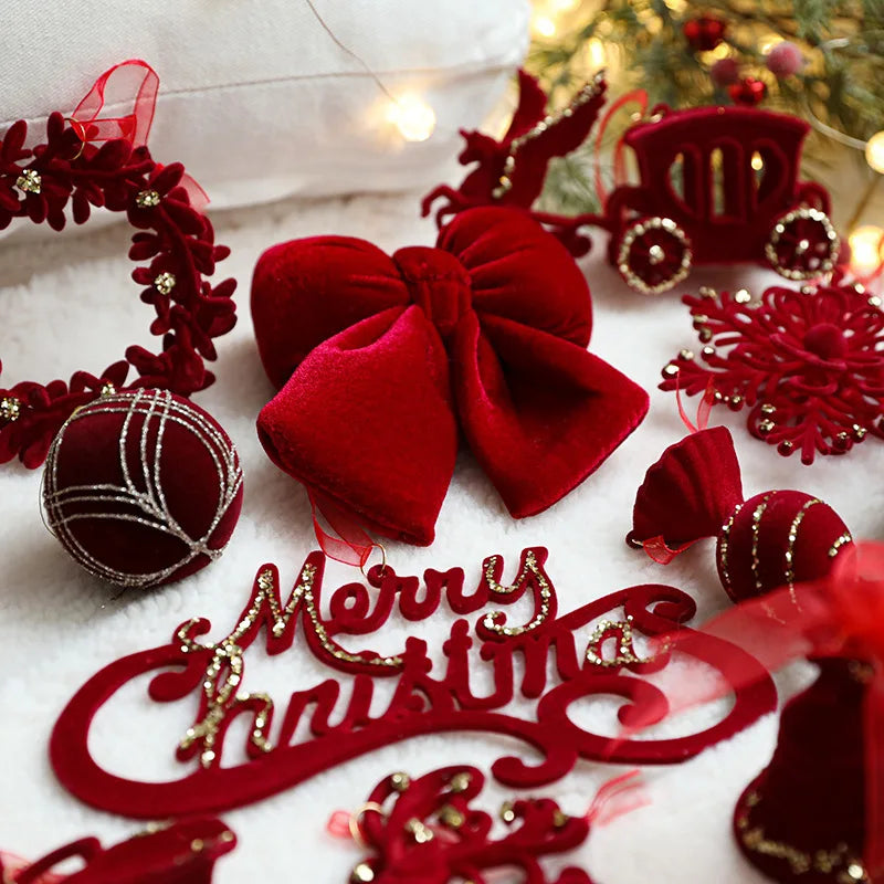 Red Christmas decorations including a bow, ornaments, and 'Merry Christmas' sign on a white surface.