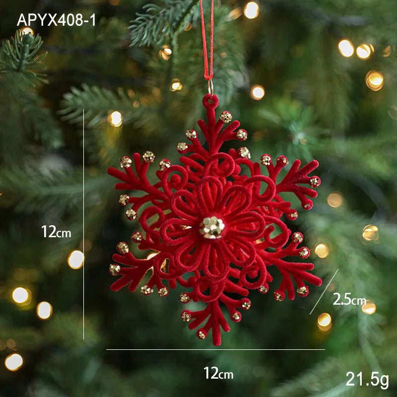 Red snowflake ornament with gold accents on a Christmas tree with blurred lights in the background