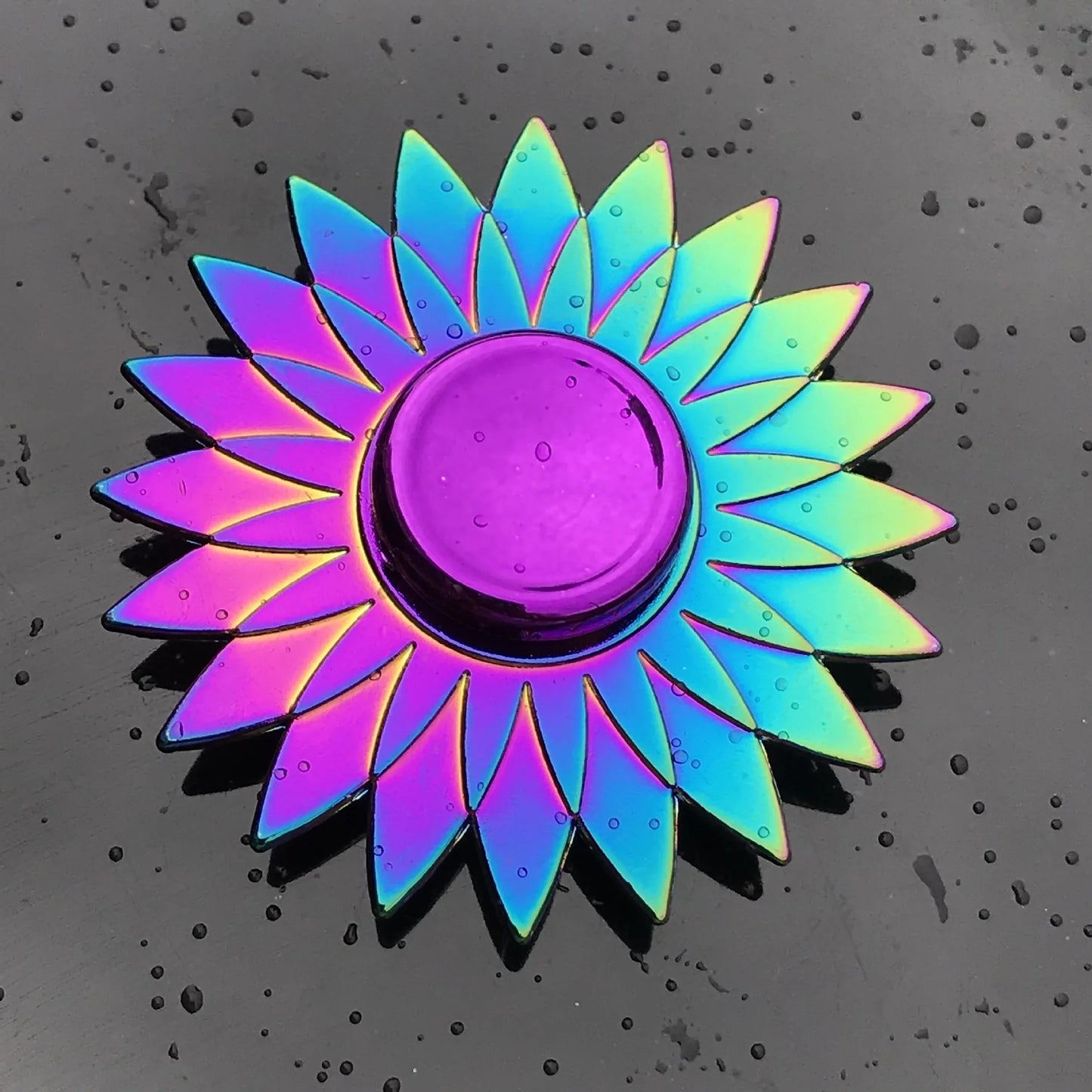 Colorful sunflower-shaped object on a textured black surface