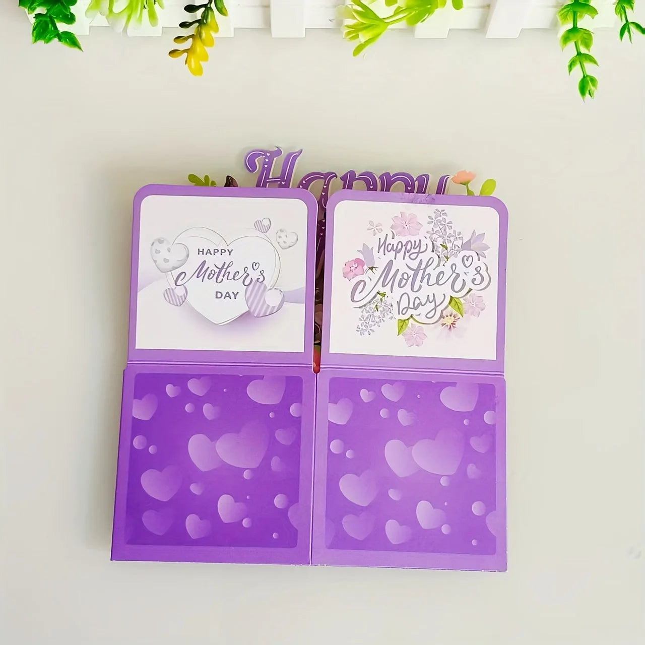 Open purple card with 'Happy Mother's Day' text and heart patterns on a light background.