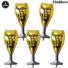 Five 'Happy New Year' wine glass-shaped balloons with yellow and silver design.