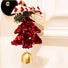 A red sequined Christmas tree ornament with a gold bell hanging below, decorated with a red and white patterned ribbon, green pine branches, and a beige ribbon that says 'Merry Christmas!'.