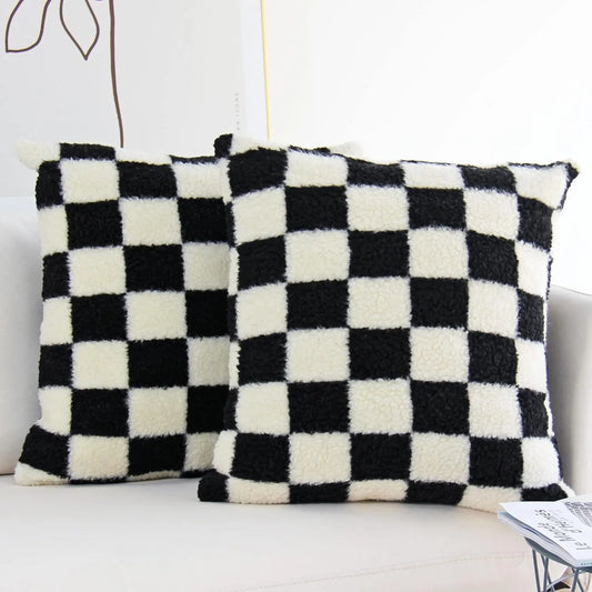 Two black and white checkered pillows on a sofa.