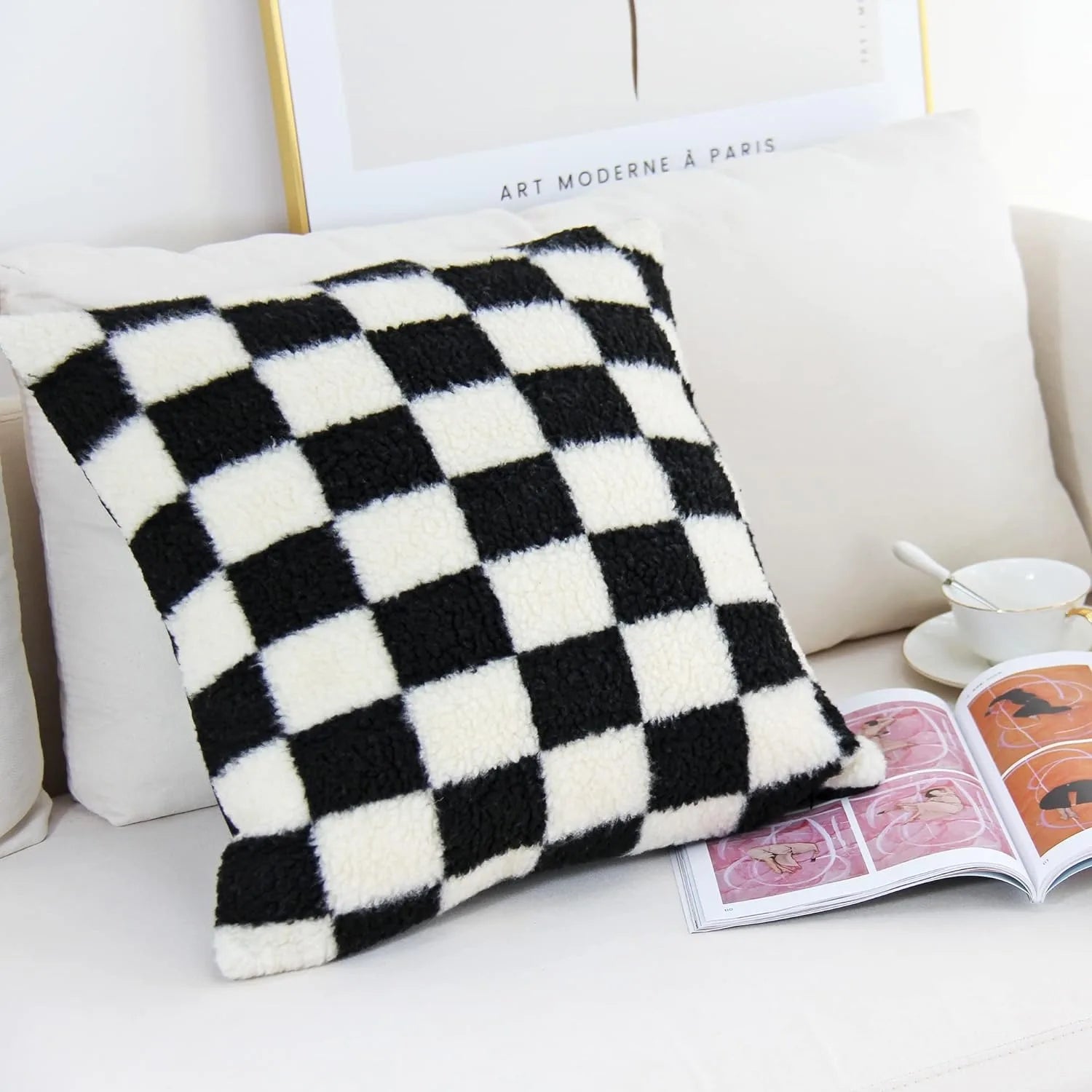 Black and white checkered blanket on a couch with a magazine and cup in the background