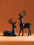 Two black deer figurines on an orange background
