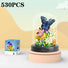 Butterfly and flower arrangement in a glass dome with packaging on a light background