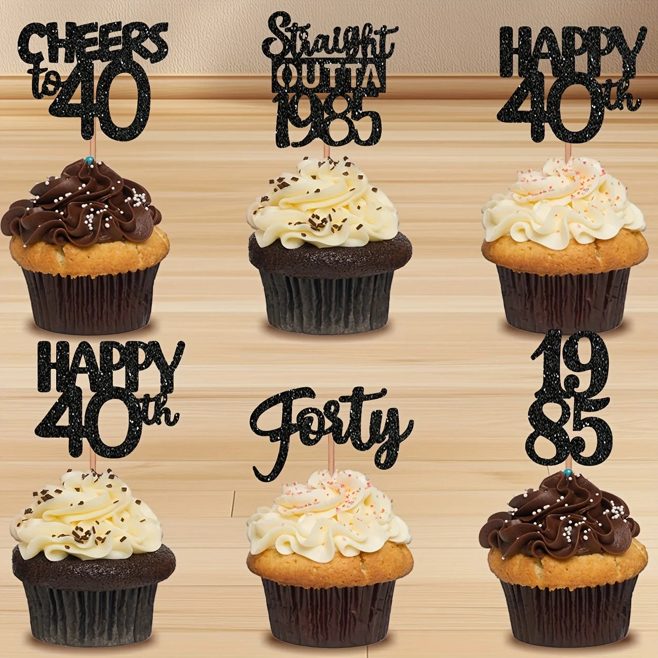 Six cupcakes with birthday-themed cupcake toppers on a wooden surface