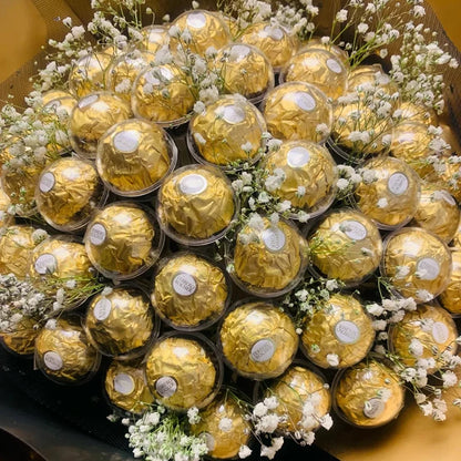 Bouquet of gold Ferrero Rocher chocolates and white flowers in a box