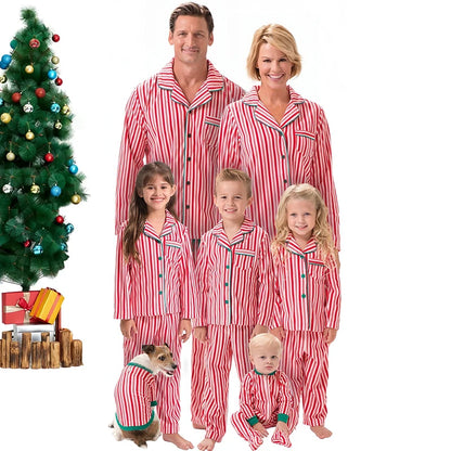 Family of five wearing red and white striped pajamas with a Christmas tree and presents in the background.