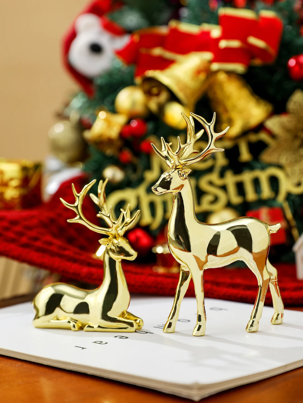 Gold deer figurines on a table with a Christmas tree in the background