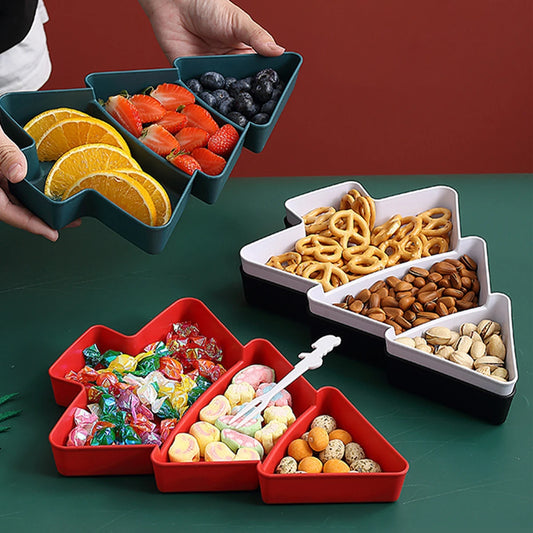 Set of colorful Christmas snack trays with various food items on a green surface.ree