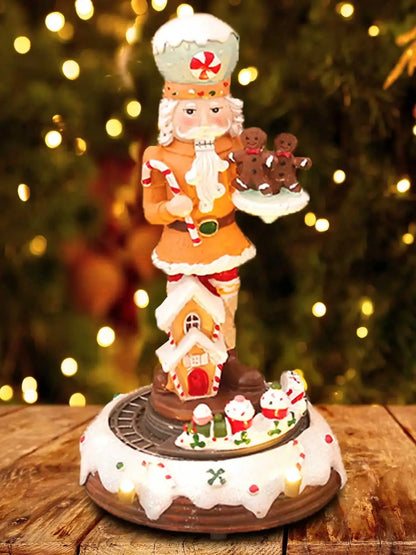 Decorative Nutcracker figurine with gingerbread men on a wooden table with a blurred Christmas tree background.
