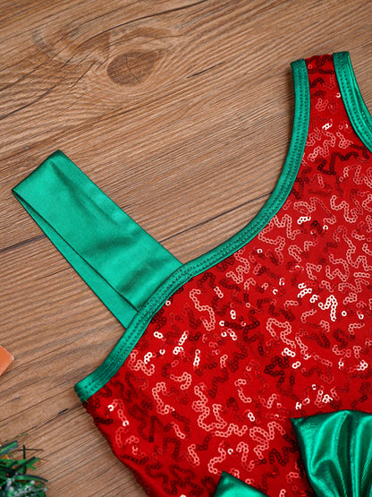A close-up of a red sequined garment laid flat on a wooden surface, with bright green satin trim and straps.