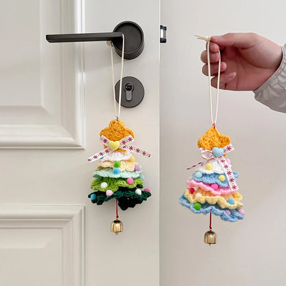 Colorful crocheted angel ornament with bells hanging on a door handle.