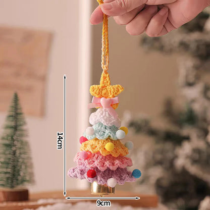 Colorful crocheted Christmas tree ornament held by a hand with measurements indicated.