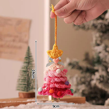 Hand holding a small crocheted Christmas tree ornament with measurements indicated.