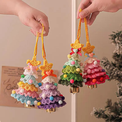 Colorful crocheted Christmas tree ornaments held by hands against a neutral background.