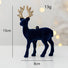 Navy blue deer ornament with gold antlers on a light gray background