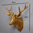 Antique Gold deer head wall decoration with measurements on a gray background