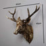 Decorative deer head sculpture with measurements on a plain background