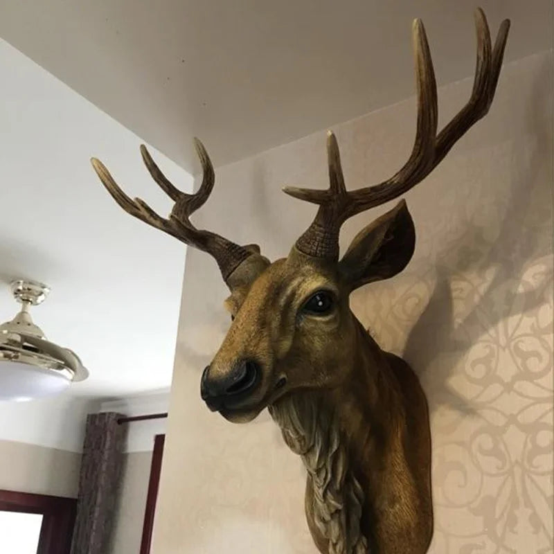 Decorative deer head with large antlers mounted on a wall.