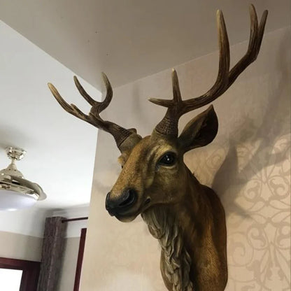 Decorative deer head with large antlers mounted on a wall.