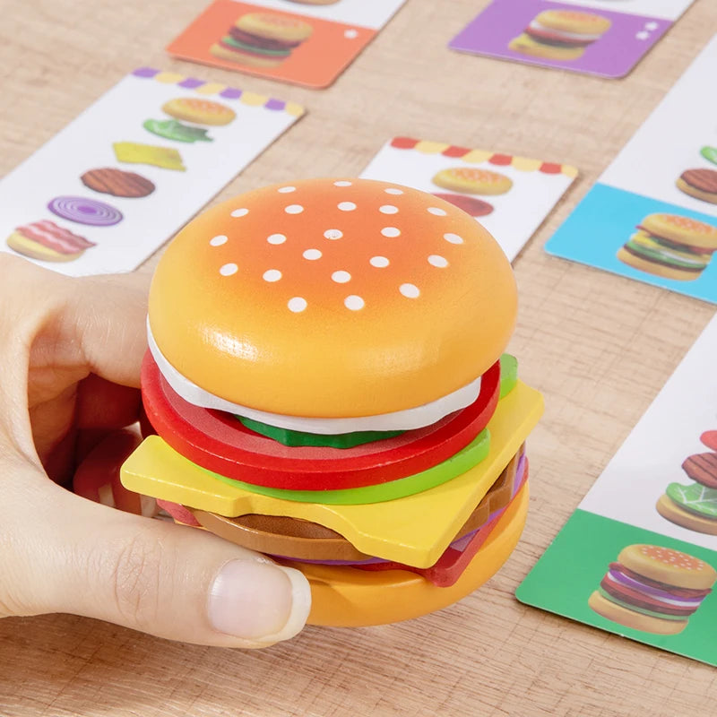 Colorful toy hamburger with educational cards in the background on a wooden surface