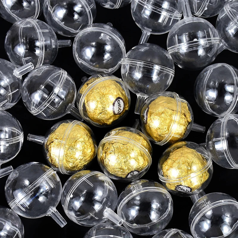 Clear plastic spheres with gold Ferrero Rocher chocolates inside on a black background