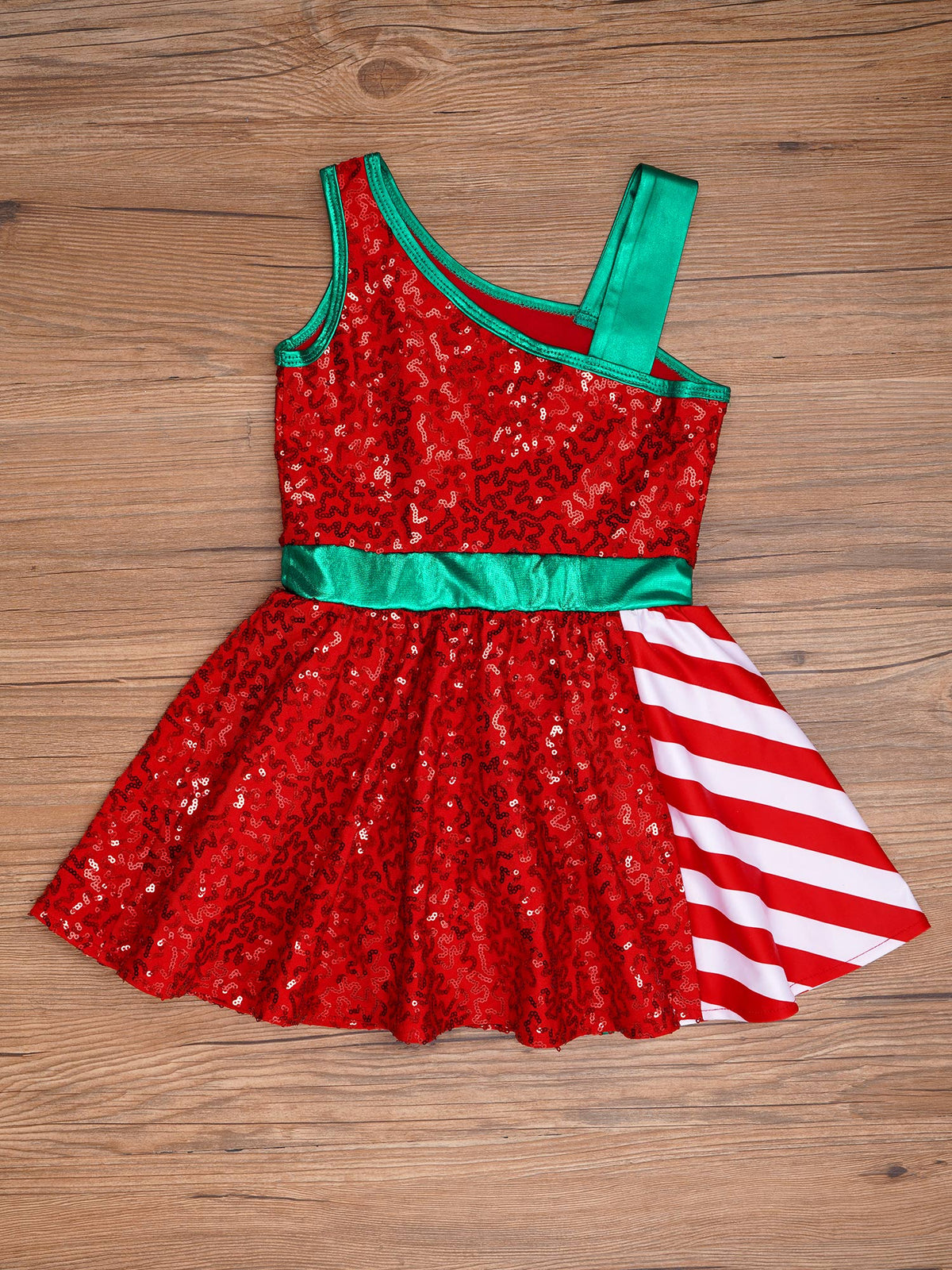 A red sequined sleeveless fancy dress with green trim and a side panel featuring red and white diagonal stripes, laid flat on a wooden surface.