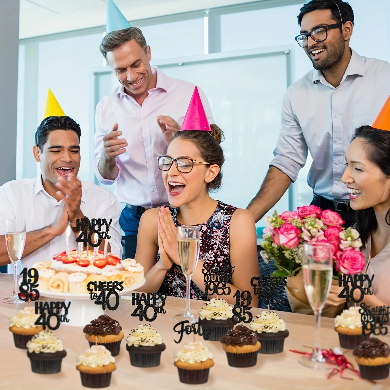 Group of people celebrating a 40th birthday with cake, cupcakes, and drinks in an office setting.
