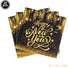 Pack of 'Happy New Year' napkins with gold text and decorative elements on a black background.