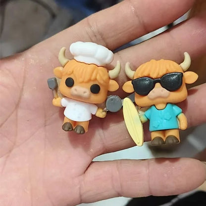 Two small figurines of a cow in chef and surfer outfits held in a hand.