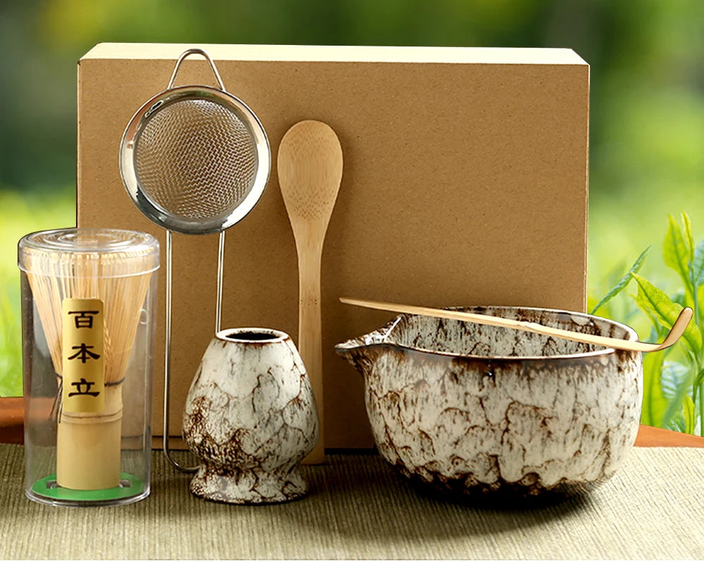 Tea-making set with a wooden spoon, strainer, and ceramic bowls on a natural background.