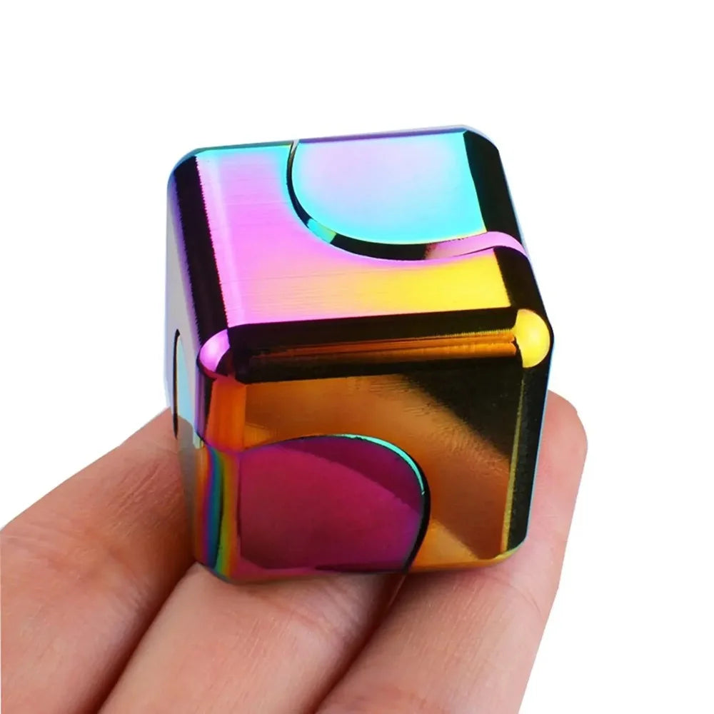 Multicolored fidget cube held in a hand against a white background