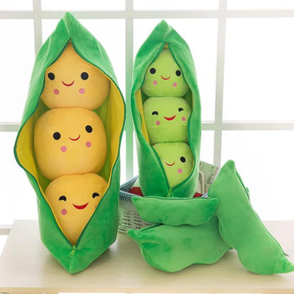 Plush toys shaped like peas in a pod with smiling faces on a white surface.
