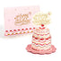 Pink birthday cake card with cherry decorations and 'Happy Birthday' topper, matching card in the background.