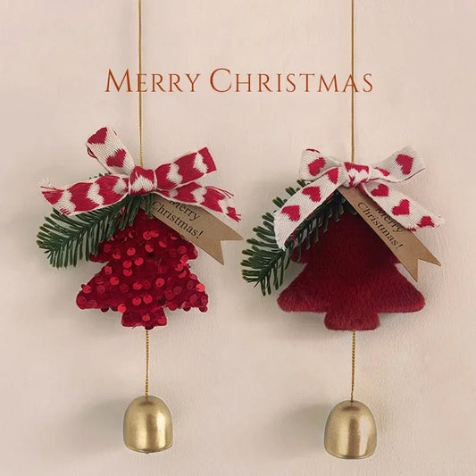 Two hanging Christmas ornaments on a light beige background with the words 'MERRY CHRISTMAS' above them. One ornament is a red sequined tree with green pine branches and a red-and-white patterned bow, and the other is a dark red plush tree with the same bow.