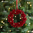 Red decorative wreath ornament on a Christmas tree with measurements and weight displayed.