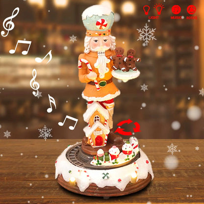Decorative Christmas nutcracker with gingerbread house and cookies on a wooden table.