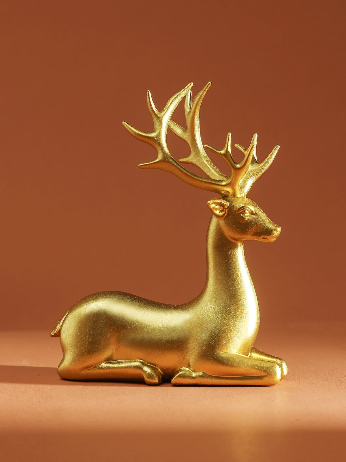 Gold deer figurine on a brown background