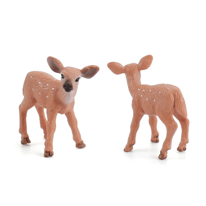 Two small plastic toy fawns in a natural brown color with white spots, standing on a white background.