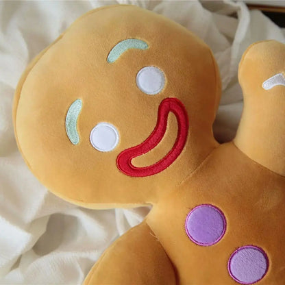 Plush toy shaped like a gingerbread man with colorful facial features on a soft white background
